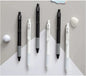 Set of black and white pens on a gray surface with decorative elements.