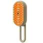 Pet grooming brush with orange bristles and beige handle on a white background